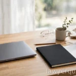 A clean desk with a closed laptop beside a blank notebook, research theme, bright daylight, no legible screen text