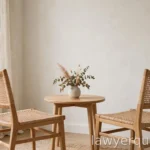 Two empty chairs facing each other across a small table in a bright neutral room, calm, no text